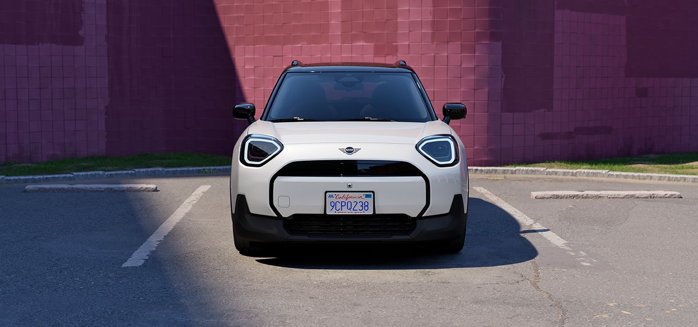 Front view of the all-electric MINI Aceman in Nanuq White and Black Roof parking.