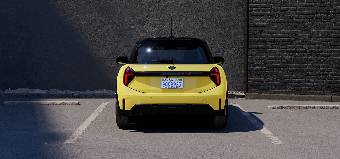 Rear view of the MINI Cooper in Sunnyside Yellow with Black Roof parking.