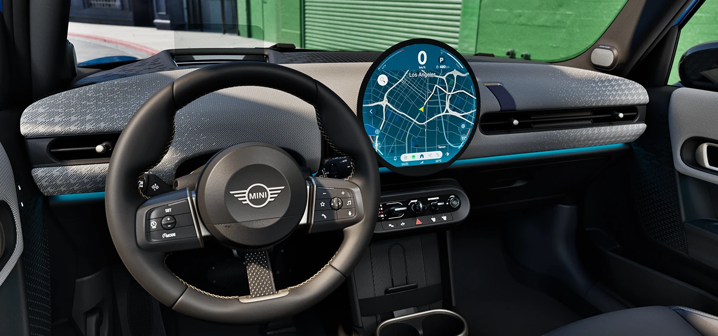 Interior view of the MINI Cooper 5-Door with focus on the steering wheel, the dashboard and the interaction unit.