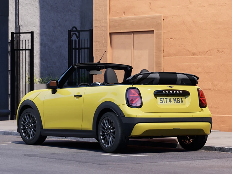 Rear left view of the MINI Cooper Convertible in Sunnyside Yellow parking.
